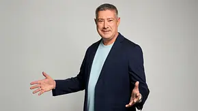 Joachim Llambi in dunkelblauem Sakko und hellblauem T-Shirt steht mit ausgebreiteten Armen vor grauem Hintergrund. - Foto: RTL / Jörn Strojny Joachim Llambi in dunkelblauem Sakko und hellblauem T-Shirt steht mit ausgebreiteten Armen vor grauem Hintergrund. - Foto: RTL / Jörn Strojny