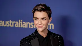 Ruby Rose steht vor einer Pressewand. Sie trägt einen schwarzen Glitzeranzug und lächelt. - Foto:  IMAGO / Starface