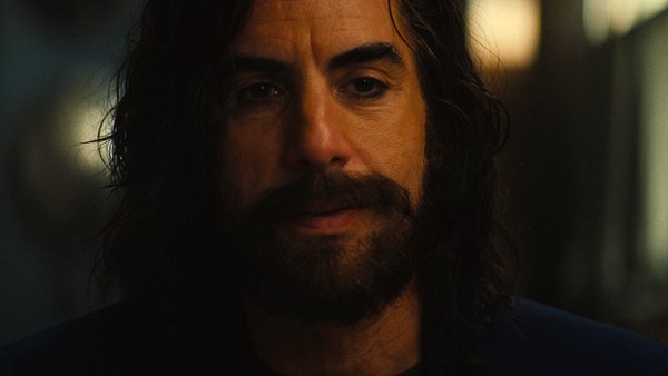 Sacha Baron Cohen als Mephisto. Er schaut leicht schmunzelnd nach vorne. - Foto: Disney+