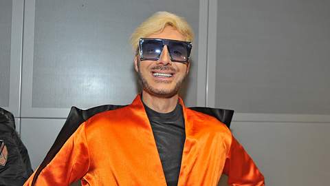 Sam Dylan lächelt in einem orangen Outfit und Sonnenbrille in die Kamera. - Foto: IMAGO / STAR-MEDIA