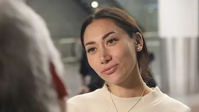 Samira Yavuz kurz vor dem Flug nach Australien am Flughafen spricht sie mit einem Reporter - Foto: IMAGO / Matthias Wehnert