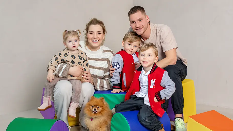Sarafina Wollny sitzt mit Peter, Feivel, Casey und Emory sowie Hund Hope für ein Fotoshooting auf bunten Elementen.