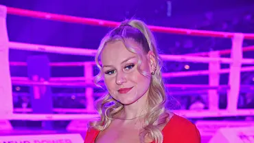Sarah-Jane Wollny steht bei einer Veranstaltung vor einem beleuchteten Boxring und trägt ein rotes Kleid - Foto:  IMAGO / Gartner