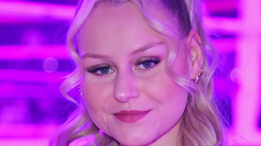Sarah Jane Wollny blickt ernst in de Kamera, sie hat die Haare halb hochgesteckt