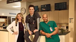 Elliot, J.D. und Turk stehen vor, sitzen auf und lehnen am Empfang eines Krankenhauses. - Foto: © 2025 Disney. All rights reserved. Elliot, J.D. und Turk stehen vor, sitzen auf und lehnen am Empfang eines Krankenhauses. - Foto: © 2025 Disney. All rights reserved.