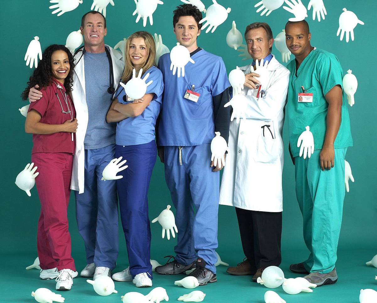 „Scrubs Man sieht den kompletten Cast von „Scrubs“ auf einem Cast-Poster.