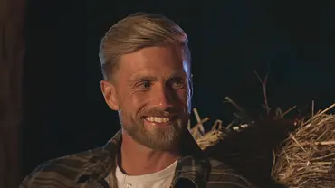 Sebastian Paul aus „Die Bachelors“ lächelt bei einem Abenddate vor Heuballen im Hintergrund. - Foto: RTL Sebastian Paul aus „Die Bachelors“ lächelt bei einem Abenddate vor Heuballen im Hintergrund. - Foto: RTL