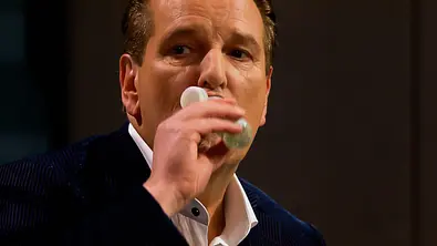 Ralf Dümmel hält ein kleines Fläschchen an den Mund. Er trägt ein dunkles Sakko über einem weißen Hemd. - Foto: RTL Ralf Dümmel hält ein kleines Fläschchen an den Mund. Er trägt ein dunkles Sakko über einem weißen Hemd. - Foto: RTL