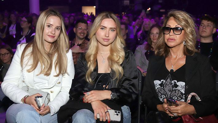 Man sieht Shania, Davina und Carmen Geiss, die „glamourös anmutend auf einer öffentlichen Veranstaltung sitzen.  - Foto:  IMAGO / Future Image