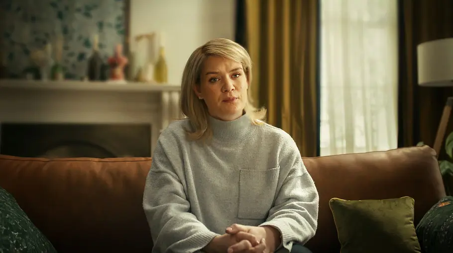 „Should I Marry a Murderer“ Caroline Muirhead sitzt auf der Couch und schaut ernst in die Kamera