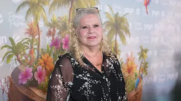 Silvia Wollny steht vor eine Fotowand der Sendung „Promis unter Palmen“.  - Foto: IMAGO / BOBO