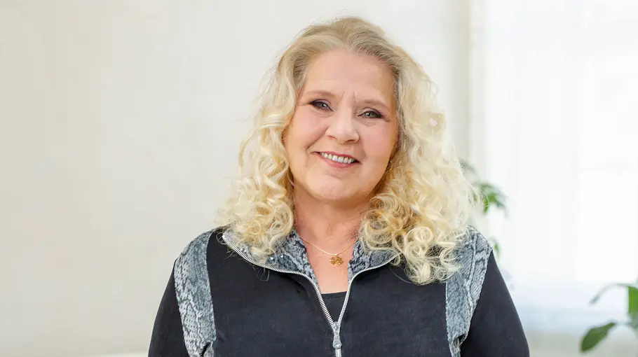 Silvia Wollny schaut für ein Fotoshooting in die Kamera und lächelt.