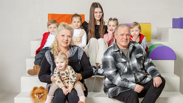 Silvia Wollny sitzt mit Harald und ihren Enkelkindern auf einer Treppe vor bunten Elementen.  - Foto: RTL2