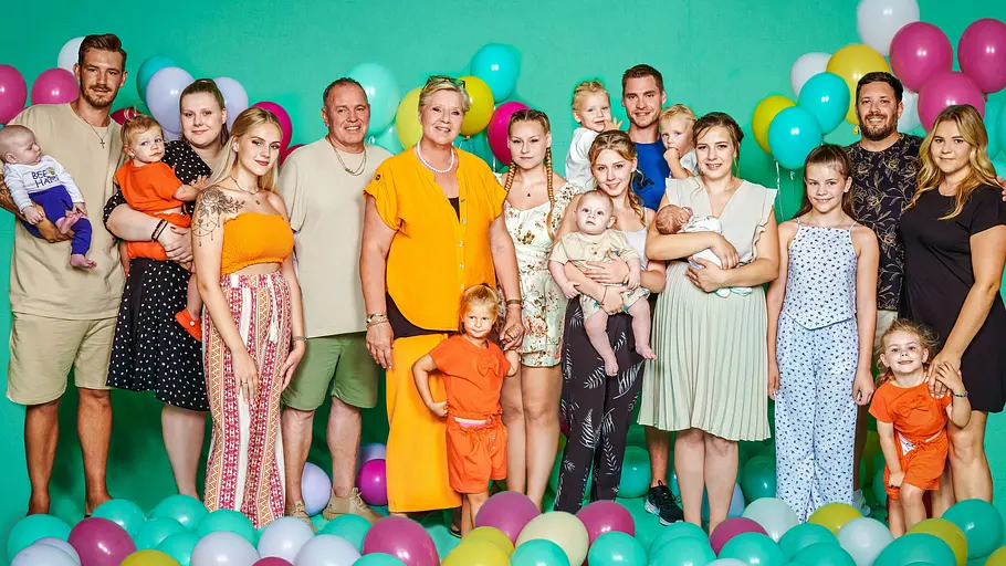 Silvia Wollny steht umringt von Luftballons und ihrer Familie vor einem grünen Hintergrund.
