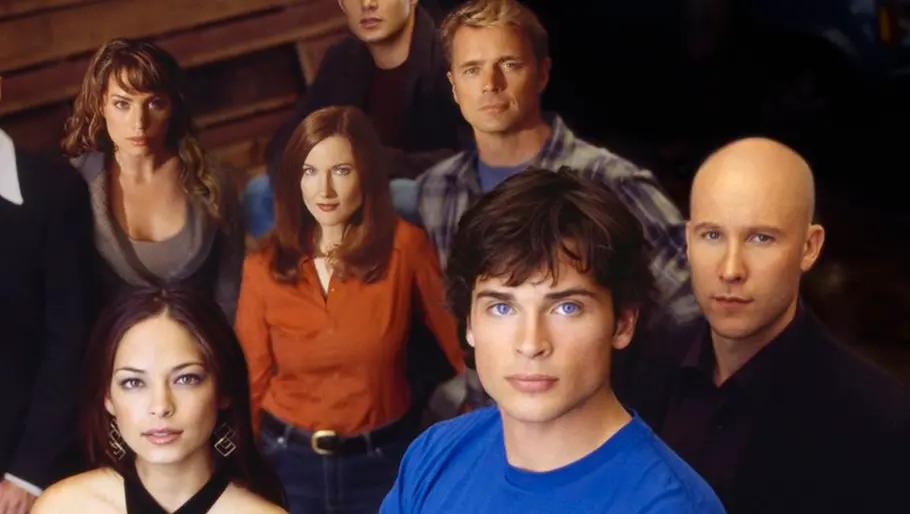 Smallville Gruppenfoto der Hauptdarsteller aus der Fernsehserie „Smallville“; die Personen stehen und sitzen zusammen vor hölzerner Kulisse und blicken direkt in die Kamera. Die Besetzung ist in Freizeitkleidung und zeigt ernste bis nachdenkliche Gesichtsausdrücke.
