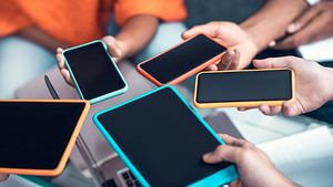 Verschiedene Smartphones werden in einem Kreis nebeneinander gehalten. - Foto: istock/Zinkevych