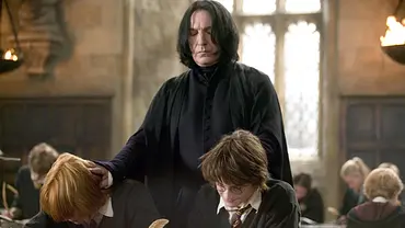 Severus Snape steht hinter Ron und Harry und drückt ihre Köpfe leicht nach vorne. - Foto: Warner Bros.