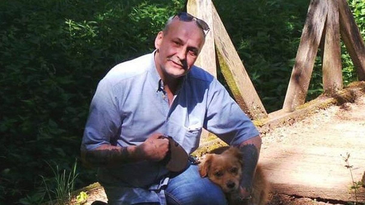 Privatfoto von Dieter Wollny Ein privates Foto zeigt Dieter Wollny 2020 in blauem Hend neben seinem kleinen Mischlingshund knien