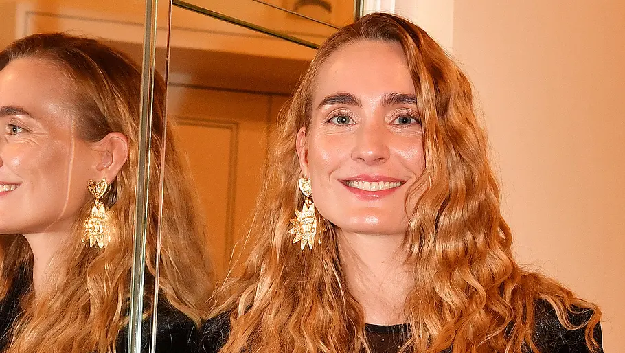 Verena Ofarims heute 2024: Verena Ofarim steht neben einem Spiegel und lächelt in die Kamera.
