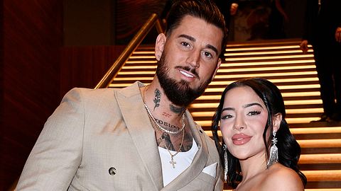 Leyla Lahouar und Mike Heiter Arm in Arm vor einer Treppe. Beide lächeln.  - Foto: IMAGO / Future Image