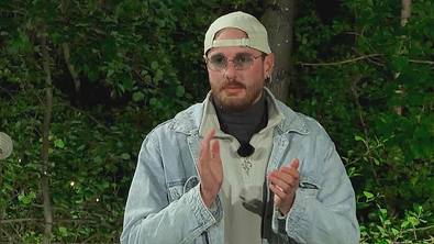 Dennis Lodi steht klatschend, er trägt eine Kappe rückwärts und eine Sonnenbrille - Foto: RTL