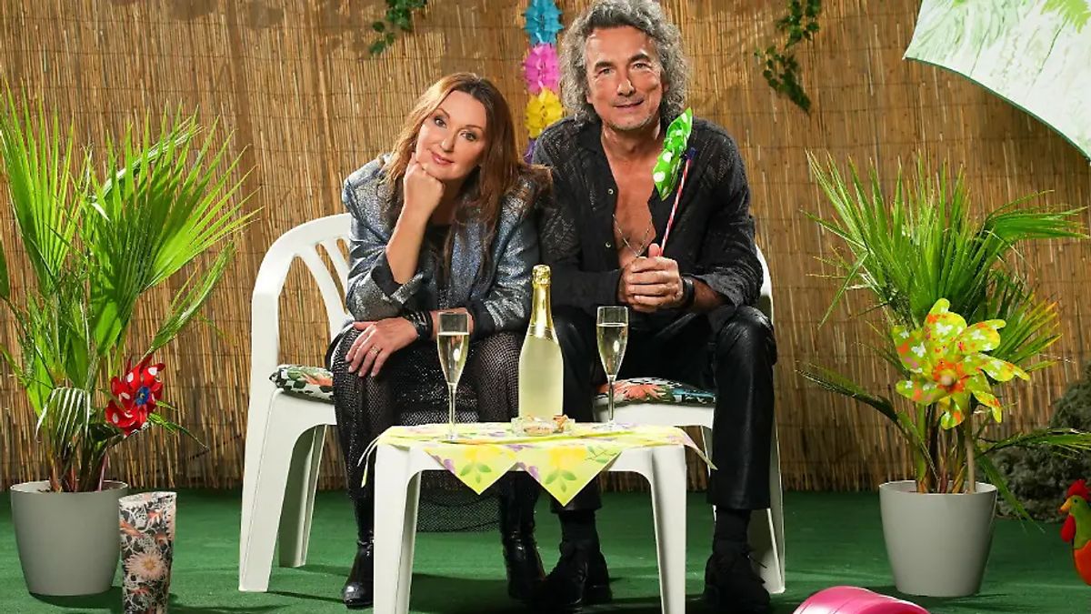 Hanka Rackwitz und ihr Partner Pierre auf zwei Plastikstühlen in der Sommerhaus-Kulisse Hanka Rackwitz und ihr Partner Pierre auf zwei Plastikstühlen in der Sommerhaus-Kulisse
