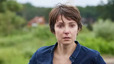 Das verschwundene Kind: Nahaufnahme: Sophie (Julia Koschitz) steht im Freien und schaut ernst seitlich nach vorne. - Foto: ZDF/Andrea Kueppers Das verschwundene Kind: Nahaufnahme: Sophie (Julia Koschitz) steht im Freien und schaut ernst seitlich nach vorne. - Foto: ZDF/Andrea Kueppers