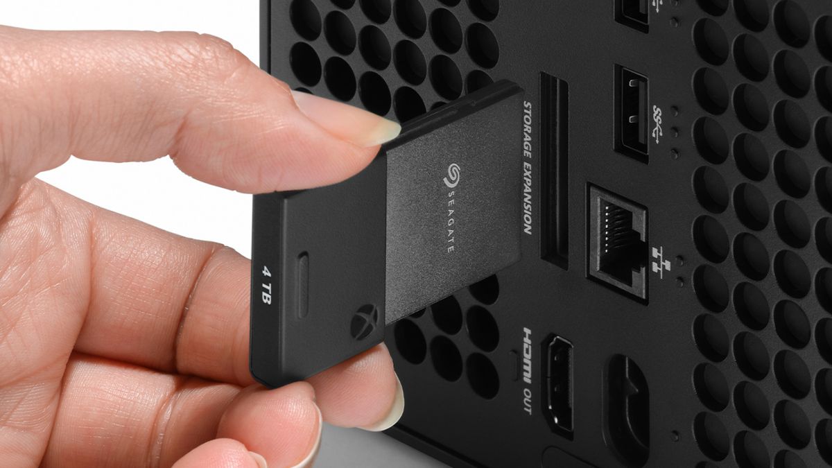 Speichererweiterung für Xbox Series X|S Eine Hand steckt eine Speicherkarte auf der Rückseite einer Xbox Series X|S ein.