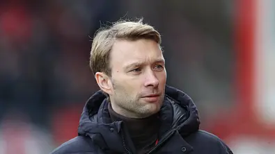 Simon Rolfes in dicker Winterjacke am Rande eines Bundesligaspiels. - Foto: IMAGO / Jan Huebner