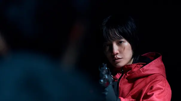 Kang No-eul hält eine Waffe und richtet sie auf einen Mann, der vor ihr steht., - Foto: No Ju-han/Netflix Kang No-eul hält eine Waffe und richtet sie auf einen Mann, der vor ihr steht., - Foto: No Ju-han/Netflix