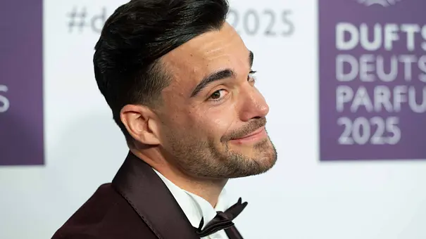 Stefano Zarrella lächelt in einem dunklen Anzug mit Fliege bei einem Event vor einer Fotowand. - Foto: IMAGO / Sven Simon