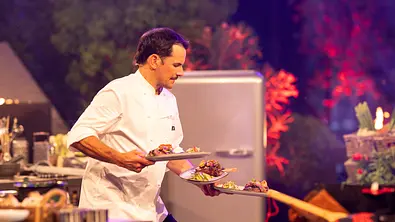 Steffen Henssler mit drei Tellern in der Hand in der Küche. - Foto: RTL / Markus Hertrich Steffen Henssler mit drei Tellern in der Hand in der Küche. - Foto: RTL / Markus Hertrich