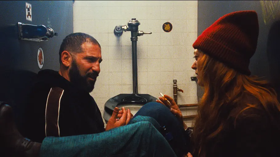 Hier sind Jon Bernthal als Michael Berzatto und Marin Ireland als Sherri rauchend in einer öffentlichen Toilette zu sehen.