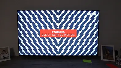 Man sieht einen modernen Fernseher mit einem Störbild. In der Mitte des TVs steht Störung. Gleich geht es weiter: - Foto: IMAGO / Hanno Bode