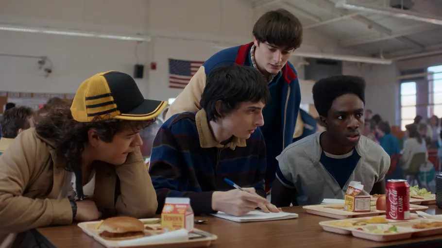 „Stranger Things 5“ Vier Teenager sind in der Schulkantine am Tisch und diskutieren miteinander.
