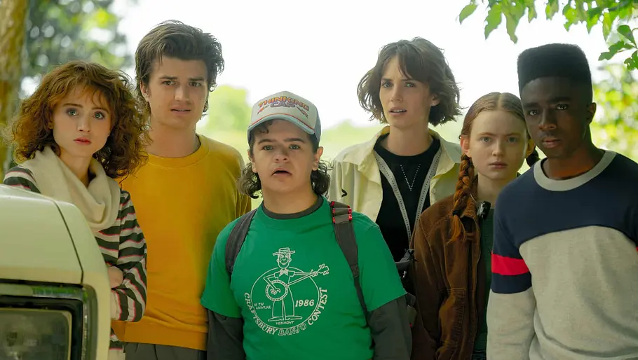 Die sechs Teenager Nancy, Steve, Dustin, Robin, Max und Lucas aus Stranger Things stehen nebeneinander und schauen verwundert in eine Richtung.