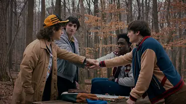 Dustin, Mike, Lucas und Will packen ihre Hände übereinander. - Foto: Courtesy of Netflix Dustin, Mike, Lucas und Will packen ihre Hände übereinander. - Foto: Courtesy of Netflix