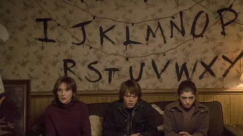 Man sieht Winona Ryder, Charlie Heaton und Natalia Dyer auf einer Couch in einem Bild der Serie „Stranger Things.  - Foto:  IMAGO / Cinema Publishers Collection