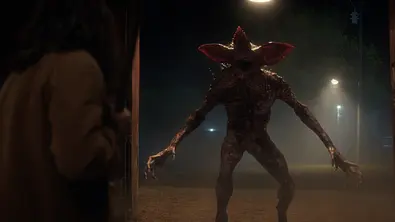 Ein Demorgorgon strht zum Angriff bereit in einer dunklen Gasse. - Foto: Courtesy of Netflix © 2025