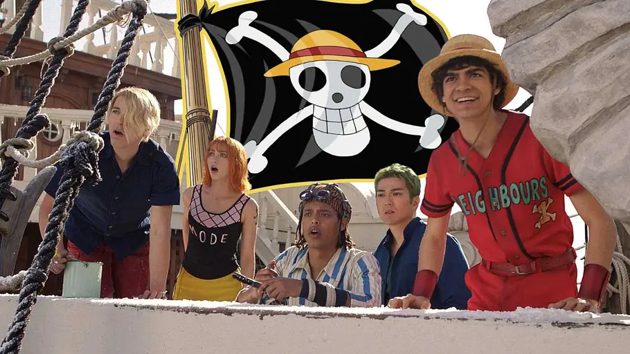 Die Live-Action.Piraten von One Piece mit ihrer Jolly Roger Die Darsteller der Netflix Live-Action-Adaption von One Piece mit ihrer Piratenflagge im Hintergrund.