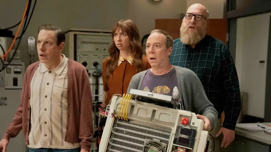 Stuart Fails to Save the Universe Kevin Sussman, Lauren Lapkus, Brian Posehn und John Ross stehen mit einer Maschine in einem Labor.