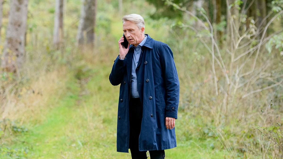 Georg steht im Wald bei Sturm der Liebe und telefoniert. Er sieht schockiert aus!