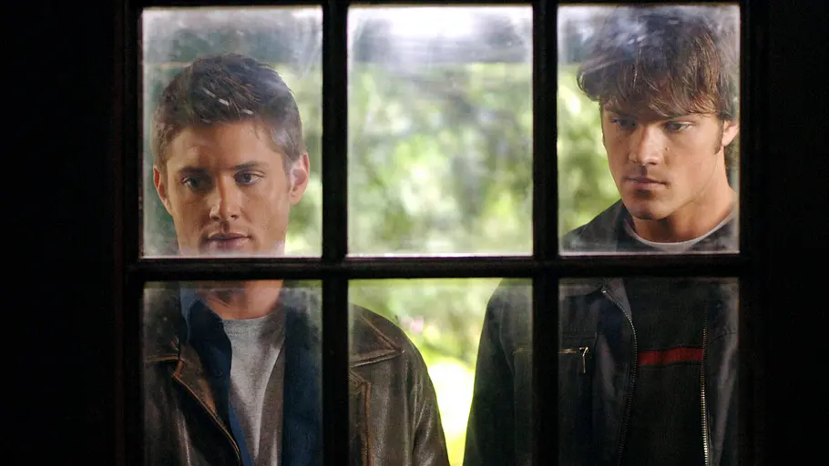 Supernatural Dean und Sam Dean und Sam stehen vor einer Tür mit Fenstern und schauen ins Haus.