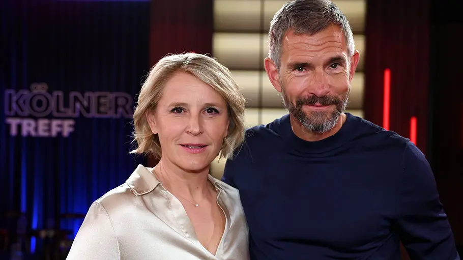 Moderatoren-Duo Susan Link und Micky Beisenherz Susan Link und Micky Beisenherz stehen gemeinsam im Studio des „Kölner Treff“ vor dem beleuchteten Sendungslogo.