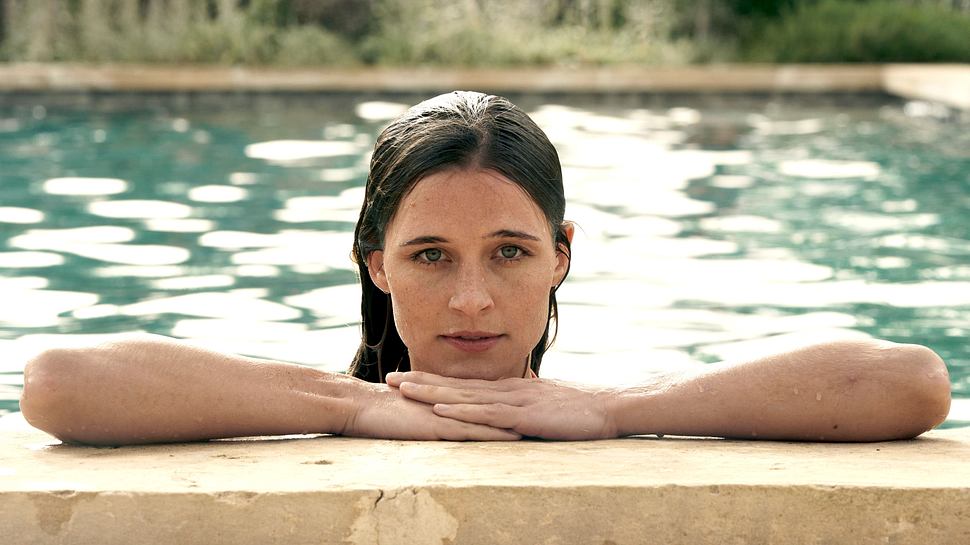 Schauspielerin Svenja Jung als Lilli im Netflix-Thriller „Fall for Me“. Sie lehnt mit nassen Haaren am Poolrand, schaut ernst und direkt in die Kamera – ihr Blick wirkt nachdenklich und verletzlich. - Foto: Julia Terjung/Netflix