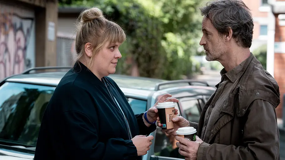 Tatort – Schmerz Stefanie Reinsperger (l.) steht neben Jörg Hartmann. Dieser hat Kaffee in der Hand.