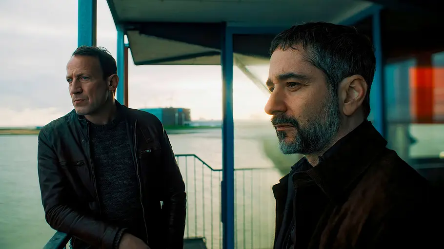 Tatort Wotan Wilke Möhring und Denis Moschitto blicken auf einem Firmengelände traurig in die Ferne.