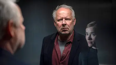Borowski steht in einem Fahrstuhl und diskutiert mit einer KI. - Foto: NDR/Thorsten Jander
