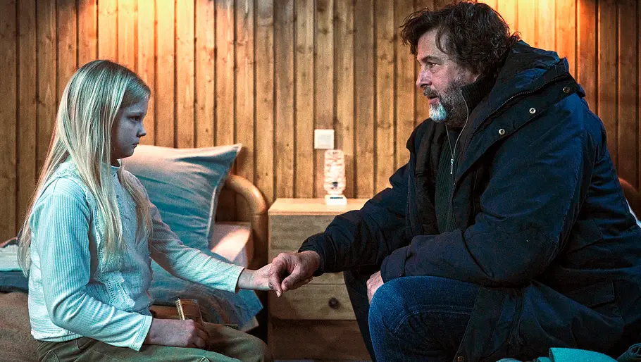 Tatort Hans-Jochen Wagner (rechts) sitzt einem kleinen blonden Mädchen gegenüber. Beide sitzen auf Betten.