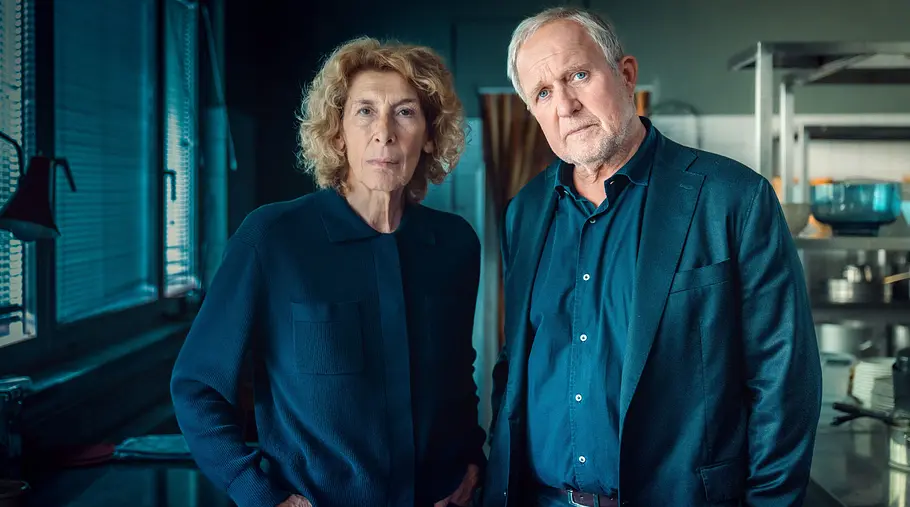 Tatort - Gegen die Zeit Adele Neuhauser (Rolle: Bibi Fellner, li.), Harald Krassnitzer (Rolle: Moritz Eisner) stehen nebeneinander und schauen kritisch an der Kamera vorbei.